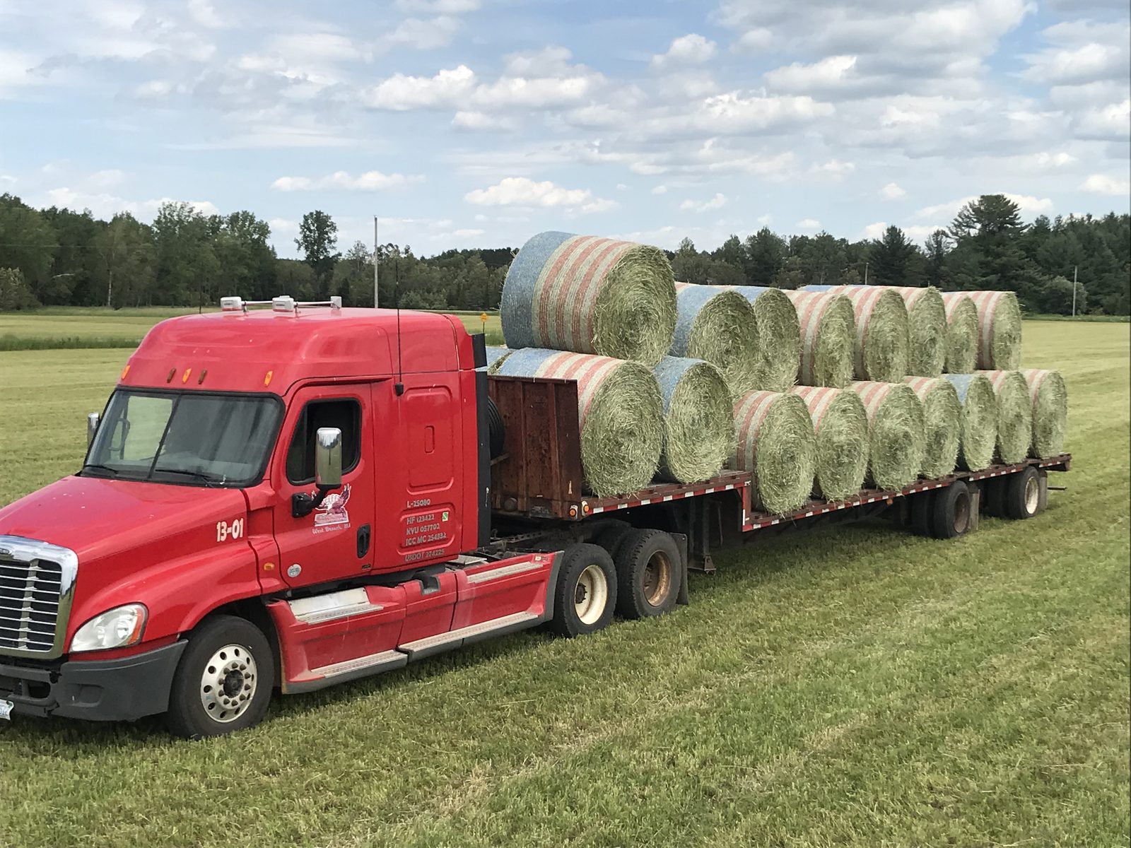 Griffin Farms flatbed truck loaded with round hay bales, ready for delivery